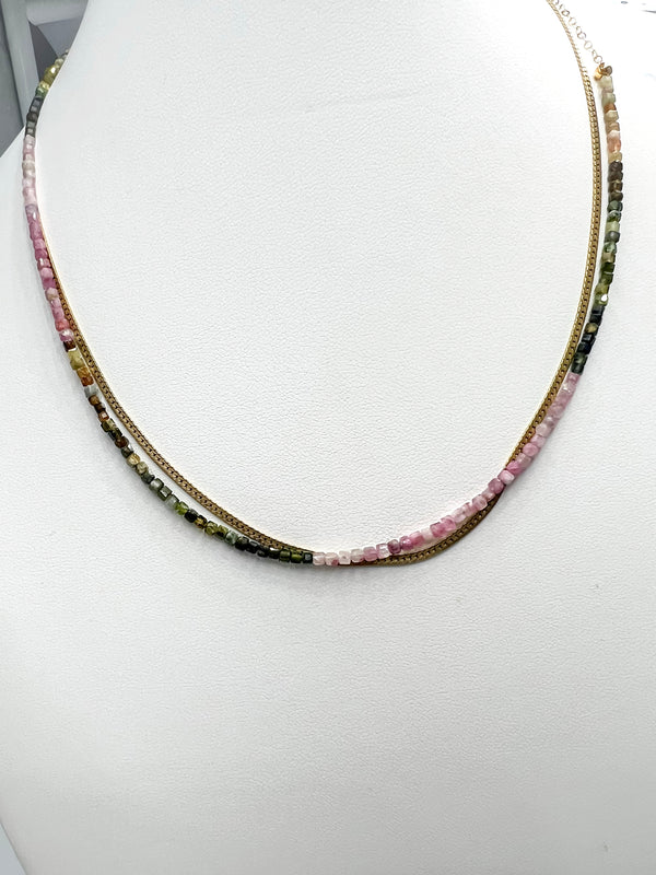 Green and pink tourmaline necklace with a 14k gold-filled clasp, stacked with a 14k gold-filled herringbone necklace over a white background.