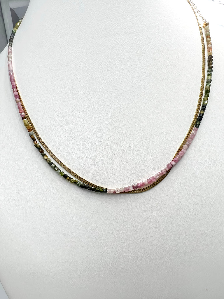 Green and pink tourmaline necklace with a 14k gold-filled clasp, stacked with a 14k gold-filled herringbone necklace over a white background.