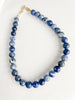 Blue sodalite necklace made with 12 mm round polished beads, 16 inches long with a 2-inch extender and a 14k gold-filled clasp, displayed on a white background.