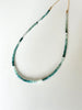 Green ombre grandidierite gemstone necklace featuring a gold clasp on a white background.