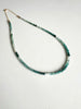 Green ombre grandidierite gemstone necklace featuring a gold clasp on a white background.
