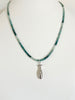 Green ombre grandidierite crystal necklace with a sterling silver fish charm displayed on a white background.
