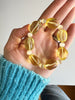 Yellow citrine beaded bracelet with pale yellow glass beads held in a hand.