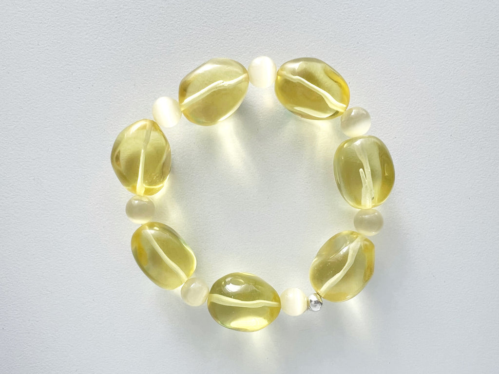 Yellow citrine beaded necklace with pale yellow glass beads, displayed on a white background.